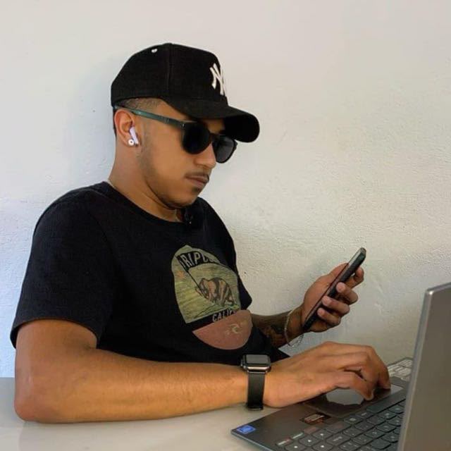 Léo Costa trabalhando no notebook e usando o celular
